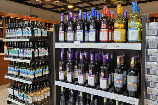 PENANG, MALAYSIA - 9 MARCH 2023: An assortment of imported wine and hard liquor bottles display neatly on store shelves in Giant Grocery store, Malaysia.