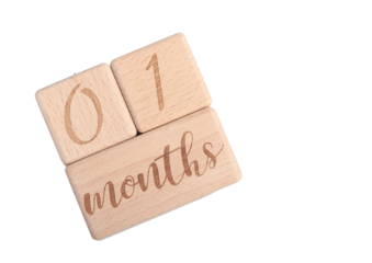A wooden block showing the date of birth of a newborn child on a white background.
