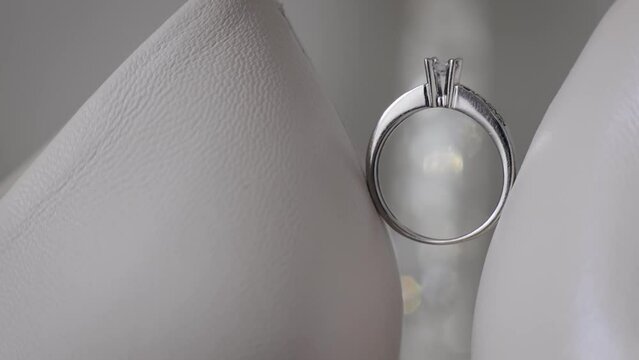 Wedding ring on woman's white shoes. Beautiful wedding ring on the bride's women sandals, wedding engagement. Close up shot with backlight sparkles