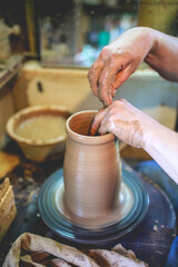 Fototapeta na wymiar Pottery workshop. Woman with hands makes a vase of clay. Clay modeling pottery 