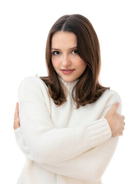 Embrace equity concept in a portrait of twenty years old brunette girl isolated on white background. Beautiful caucasian young woman in white sweater hugging herself and posing in studio.
