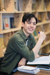 Young Asian man studying at library
