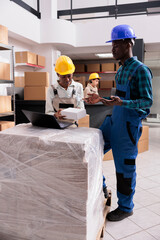 Storehouse operator explaining assistant online customer order picking and packing. E commerce stockroom workers holding package, analyzing goods list on laptop and preparing parcel for shipping