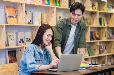 Young Asian couple studying at library