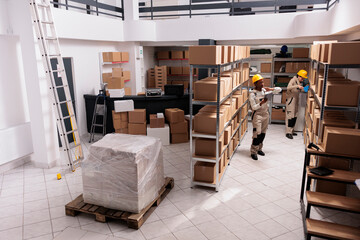 Diverse warehouse workers packing packages and checking parcels in stockroom. Delivery company...