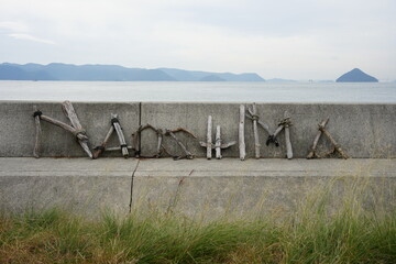 瀬戸内海・直島の防波堤に置かれた流木のアート