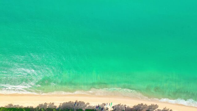 .aerial top view above white sand beach..turquoise sea at Thy Maung beach Phang Nga. 4k colorful blue sea background..beautiful nature in the long beach with pine trees. fishing boat background...