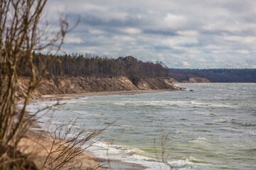 Stormy weather conditions at sea and big waves crashing on the beach and steep bank Latvia, Baltic sea