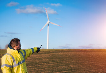 person standing next to wind turbine