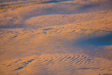 Sunset sand dunes with shadows on the beach