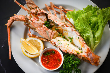 spiny lobster food on white plate, fresh lobster or rock lobster seafood with herb and spices lemon coriander parsley lettuce salad, lobster for cooking food and seafood sauce