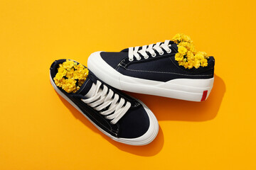 Concept of shoes - sneakers with flowers, top view - obrazy, fototapety, plakaty
