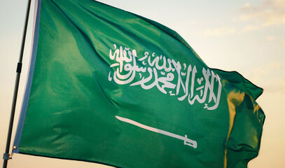 Concept of Saudi Arabia Flag Waving, Celebration, Saudi Arabia, Flag, National, Independence Day, Patriot. Close-up Saudi Arabia national flag waving in the wind against sunset, soft focus