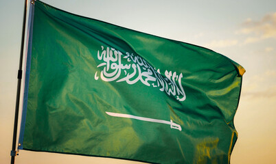 Concept of Saudi Arabia Flag Waving, Celebration, Saudi Arabia, Flag, National, Independence Day, Patriot. Close-up Saudi Arabia national flag waving in the wind against sunset, soft focus