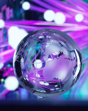 Fibre optics reflected on glass globe against colored background