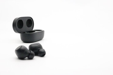 Black bluetooth earphones with white background.