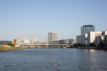 Germany, Hamburg, Elbe river flowing through HafenCity with bridge and large construction site in background