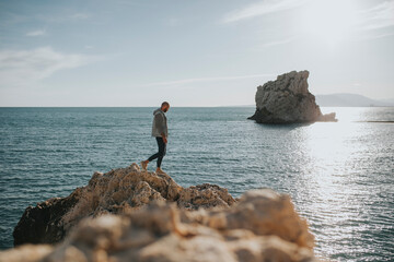 Man walking on rock in front of sea