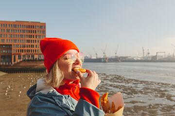 Woman wearing sunglasses eating fish and chips