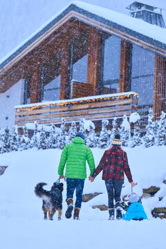 Parents with son and dog walking in snow