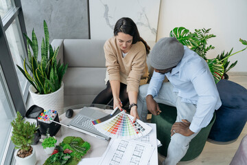 Architect discussing with colleague over color swatches at workplace