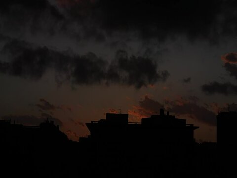 Time lapse delle nuvole su uno skyline cittadino a Catania, con palazzi e antenne tv, al tramonto