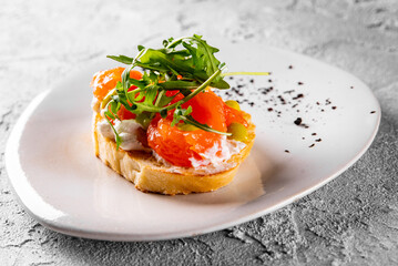 Bruschetta with salmon, cream cheese and arugula on plate