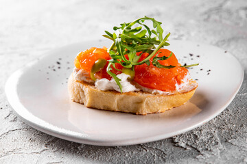 Bruschetta with salmon, cream cheese and arugula on plate