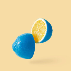 Lemon sureal playful with a blue skin cut into two parts levitation above the background. A crazy fruit. High quality photo
