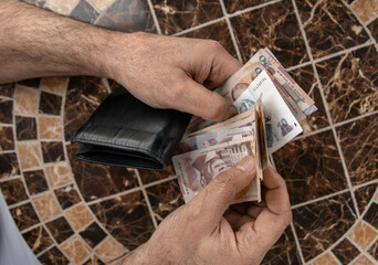 a man counts money at the table. Georgian banknotes in the hands of a tourist. Georgian lari