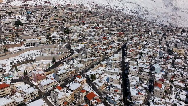 Mountainside Town houses covered with snow, Fly over