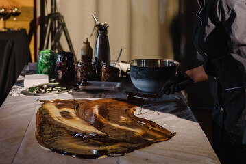 Woman pouring hot chocolate cooled liquid nitrogen. Pastry chef wearing black uniform cooking...