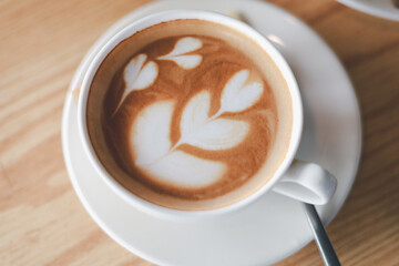 Hot cappuccino, vintage style coffee powder and coffee beans with green leaves On a black background
