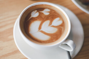 Hot cappuccino, vintage style coffee powder and coffee beans with green leaves On a black background
