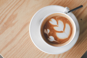 Hot cappuccino, vintage style coffee powder and coffee beans with green leaves On a black background

