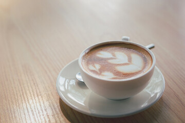 Hot cappuccino, vintage style coffee powder and coffee beans with green leaves On a black background
