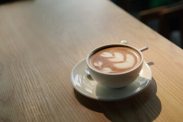 Hot cappuccino, vintage style coffee powder and coffee beans with green leaves On a black background
