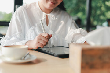 Fototapeta premium Young beautiful business woman working on laptop at coffee shop concept of independent living, working lifestyle 