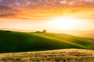 Obraz premium amazing sunset among green spring hills in highland farm with castle , mountains and picturesque colorful sunset on background of landscape