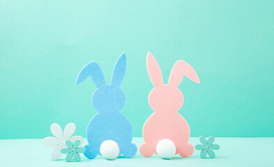 Easter Pink and Blue Felt Bunnies, Wooden White Spring Daisy Flowers on Mint Background.