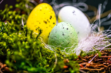 bird  nest with colored Easter eggs on branches of green trees, easter decoration, selective focus