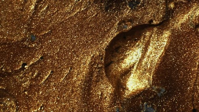 Glitter paint. Ink flow. Molten gold. Defocused shimmering bronze brown color bubble texture fluid wave motion abstract background.