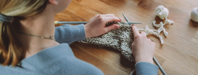 Knitting.Girl knitting at home.Handmade zero waste,upcycling,New small business employment opportunity concept.Hobby knitting and needlework for mental health.Knitted background,eco friendly knitting