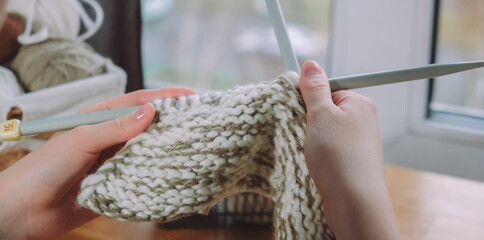 Knitting.Girl knitting at home.Handmade zero waste,upcycling,New small business employment opportunity concept.Hobby knitting and needlework for mental health.Knitted background,eco friendly knitting