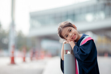 Happy Asian girls in graduation gowns on their graduation day at school.Graduation concept with copy space.
