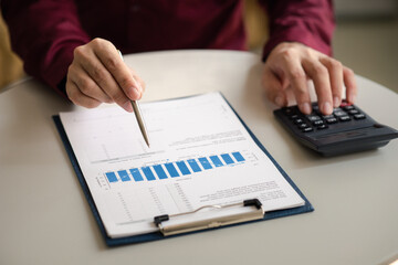 A financier is reviewing company financial documents, monthly financial statement summary from the finance department. The concept of managing the company's finances for accuracy and growth.