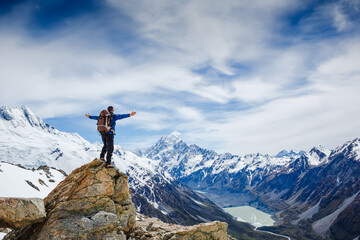 Hiker on the mountain top with his hands outstretched. Sport and active life concept