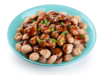 Soy meat in a plate with teriyaki sauce and onion isolated on white background. Vegan meat.