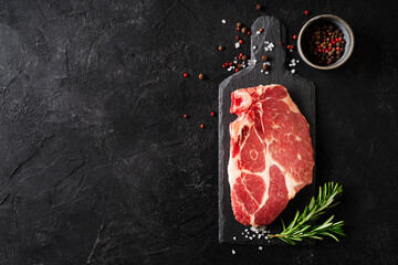 Fototapeta Raw fillet meat pork on board with peper seasoning and green rosemary obraz