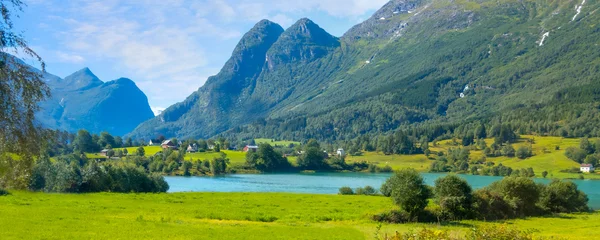 Poster Norwegian landscape with Nordfjord fjord, summer mountains and village in Olden, Norway © Nataliya